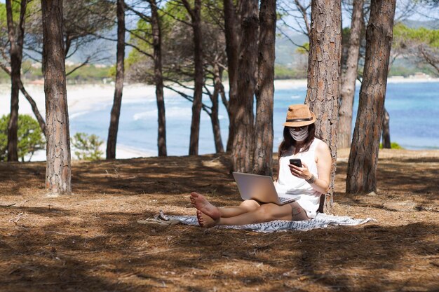 A person sitting on a beach, relaxing and reading a book, with a laptop nearby. This image symbolizes the flexibility and freedom afforded by financial independence. The sky is clear, and the overall tone is peaceful and serene.