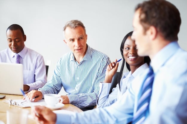 A group of employees sitting in a conference room, listening to a presentation about changes to their employee benefits package, including details about the healthcare reform bill.
