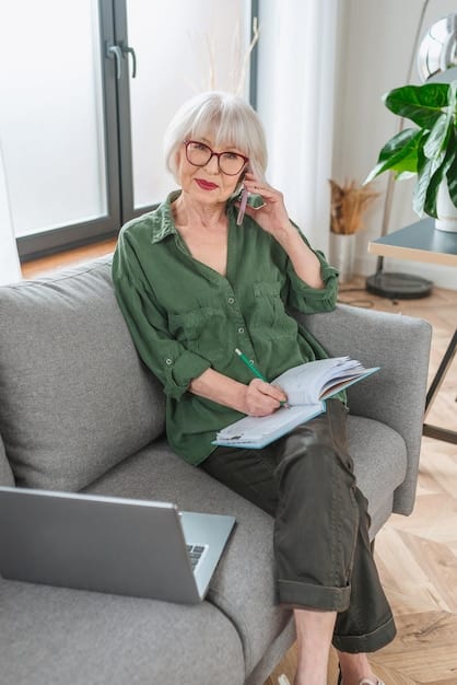 An elderly woman smiling warmly as she sits in a comfortable chair, reviewing documents with her adult daughter. The scene is set in a cozy home office, emphasizing trust, family support, and proactive planning.