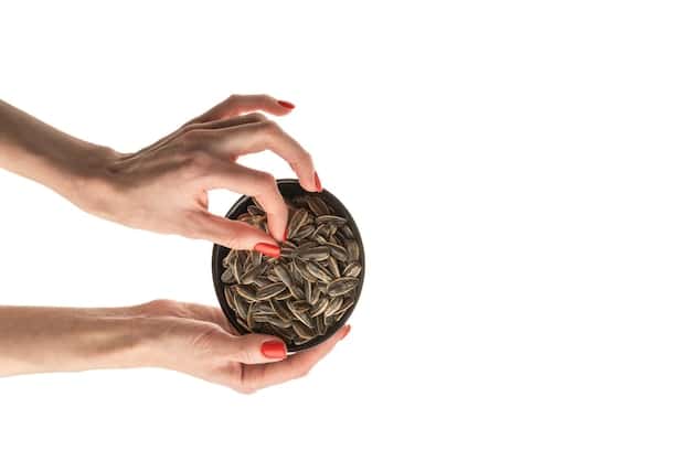 A split image showing two hands. One hand is placing coins into a piggy bank, representing savings, while the other hand is using a laptop to explore investment options. The background suggests a college campus, symbolizing the link between financial planning and educational opportunities.